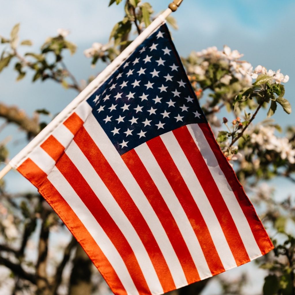 American flag hanging outside. Red white and blue, stars and stripes.